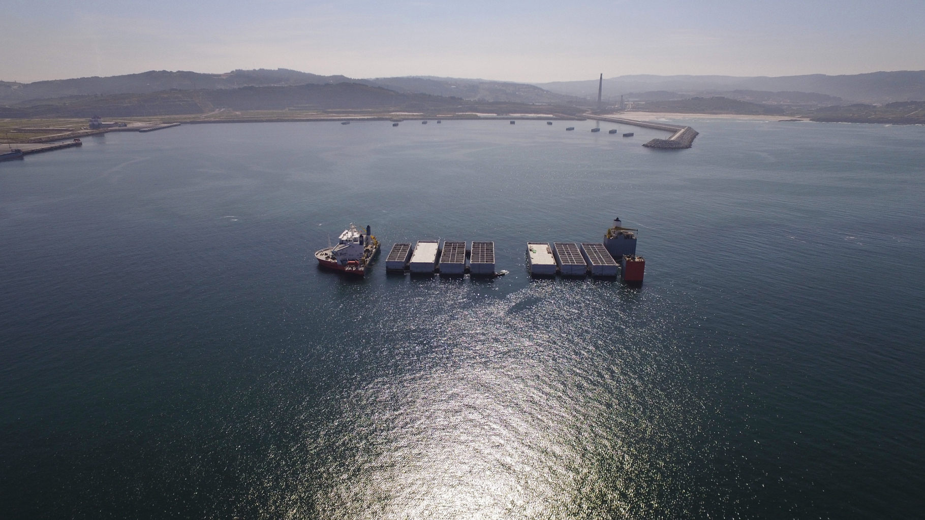 Fotografía con drone en el puerto exterior de A Coruña, del proceso de carga de bloques de hormigón para la construcción de puerto en Escocia. Trabajo realizado para Dragados